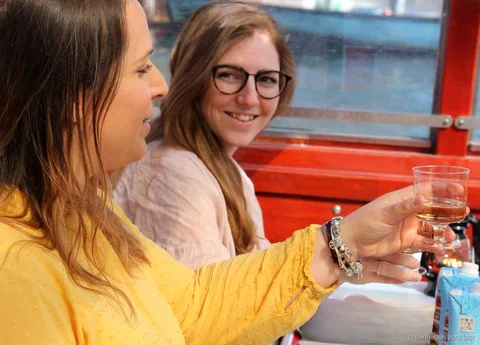 Gruppe nyder drinks på en overdækket kanaltur i København