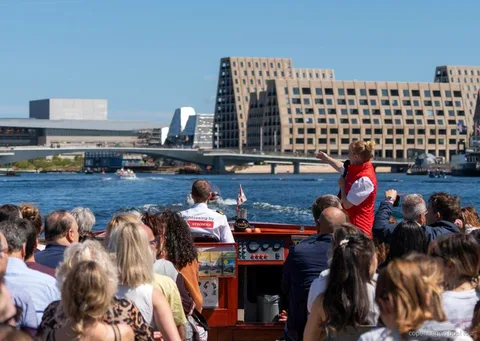Copenhagen canal boat tour passing Christiansborg Palace along the water