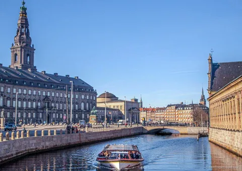 Copenhagen canal cruise boat with drinks served onboard passing the harbor