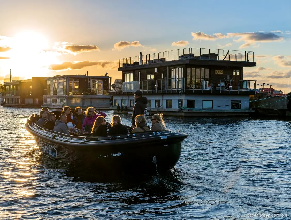 Small boat on the Copenhagen hidden gems boat tour passing modern Nordhavn buildings