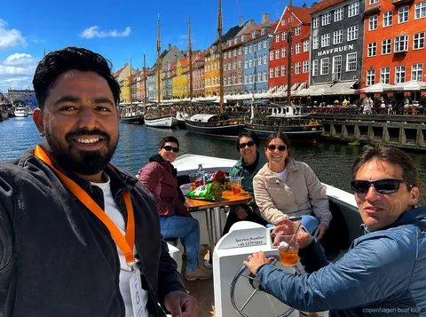 Small guided boat on the Copenhagen luxury boat tour passing harbor landmarks