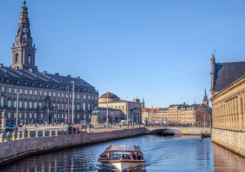 Barca della crociera sui canali di Copenaghen con drink serviti a bordo davanti al porto