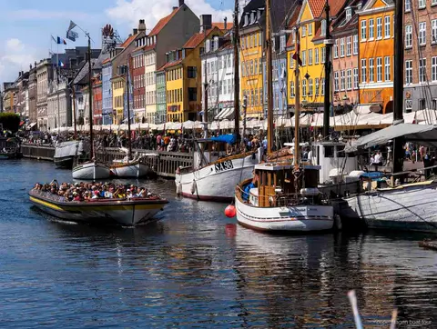 Guide commentant la croisière sur les canaux de Copenhague près de la statue de la Petite Sirène