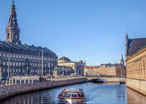 Barco del crucero con copas por los canales de Copenhague sirviendo bebidas mientras pasa por el puerto