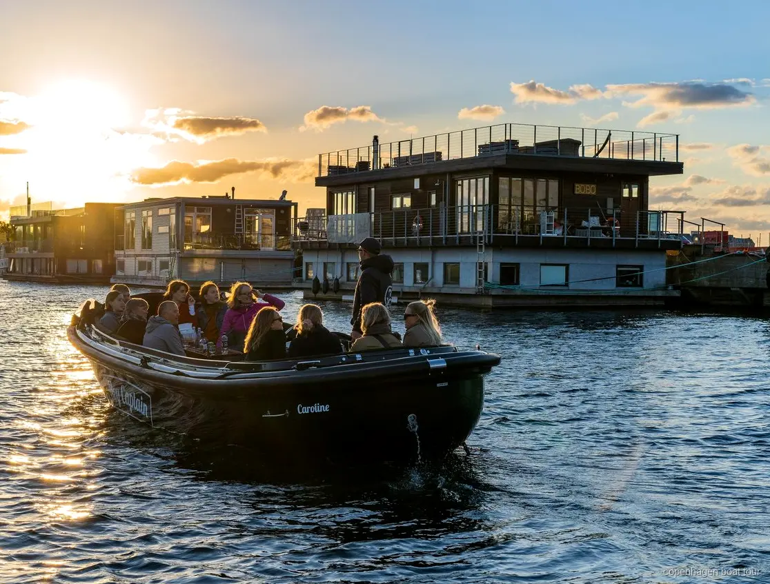 Liten båt på turen med dolda pärlor i Köpenhamn förbi moderna Nordhavn-byggnader