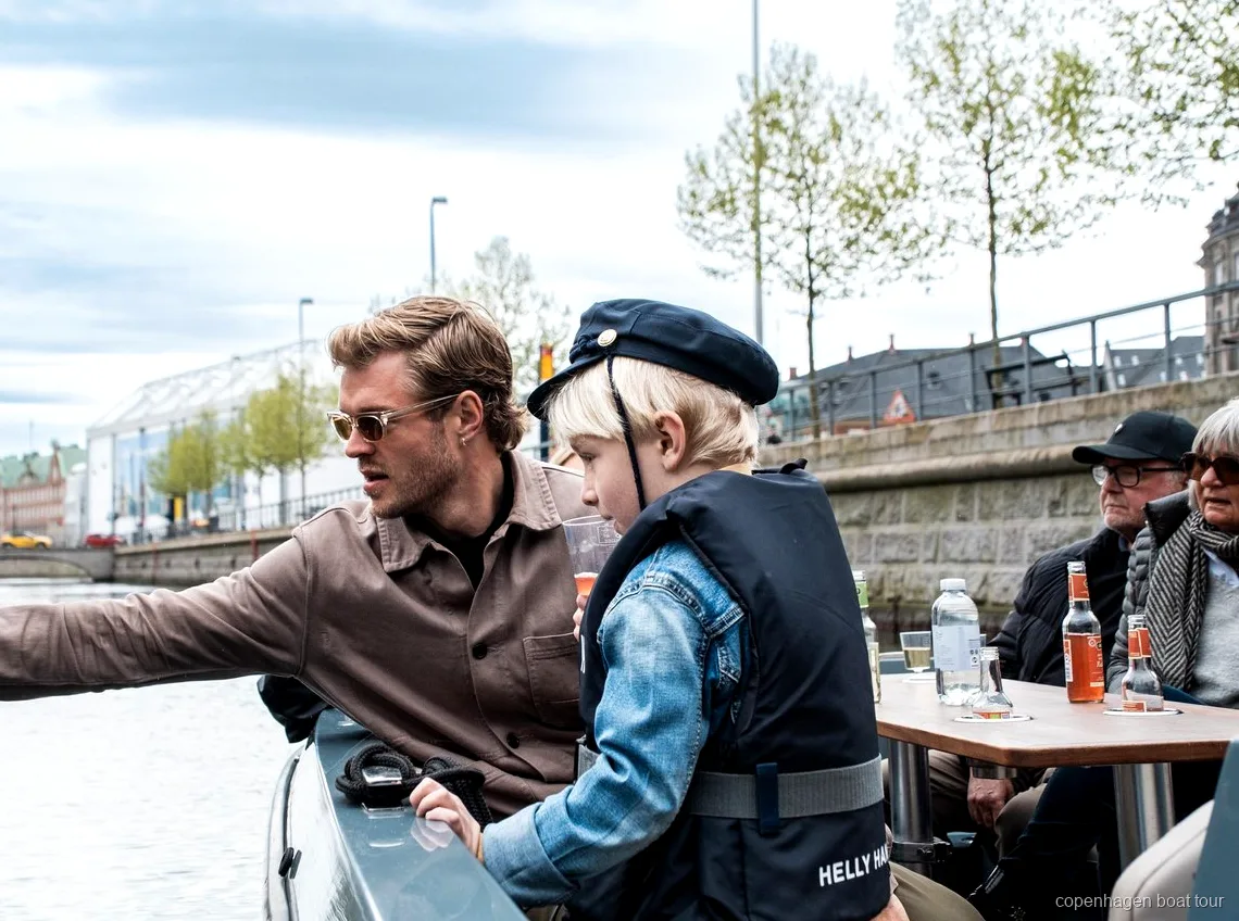 Lille gruppe passagerer på den elektriske kanaltur i København nær Nyhavn