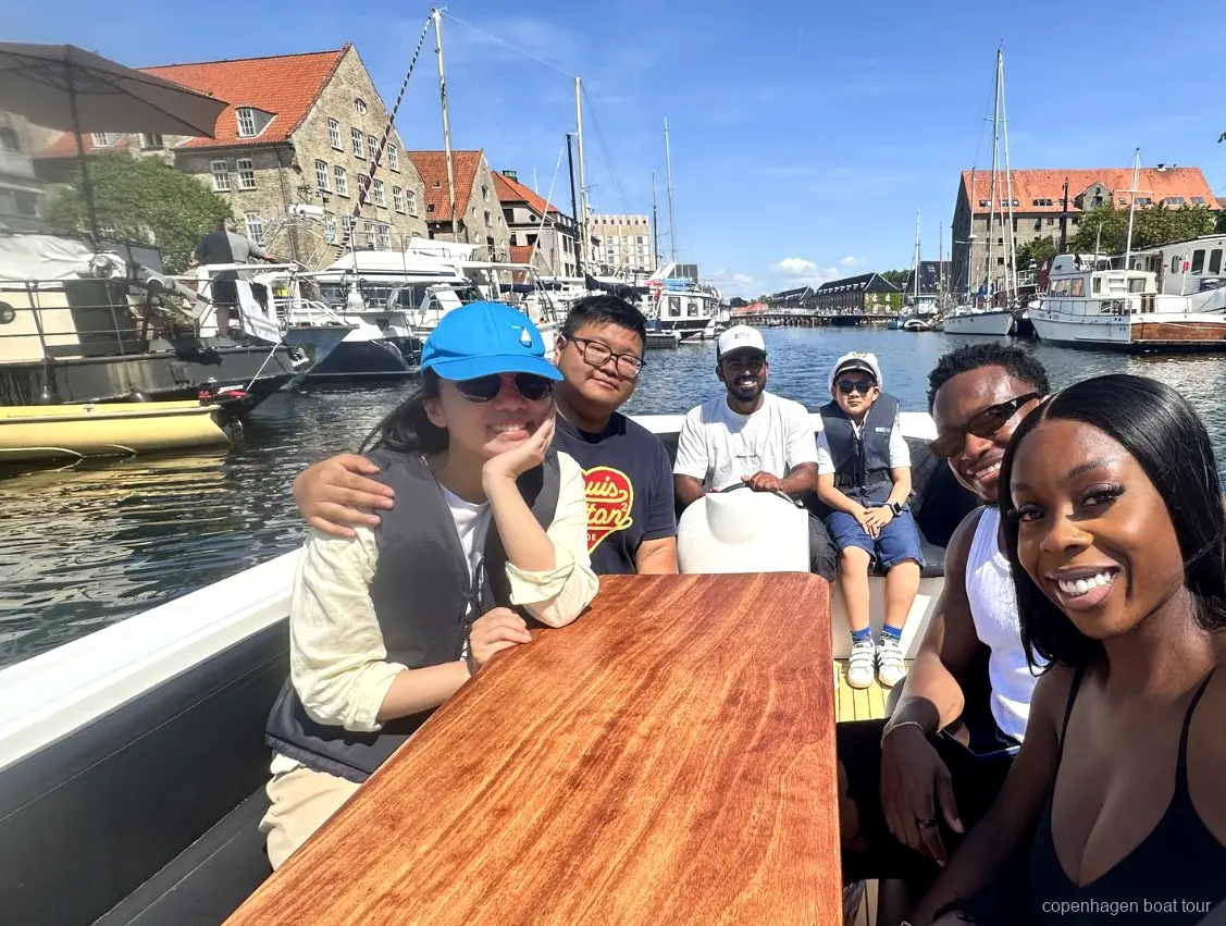 Visitatore che guida la barca sotto supervisione durante il giro in battello di lusso a Copenaghen