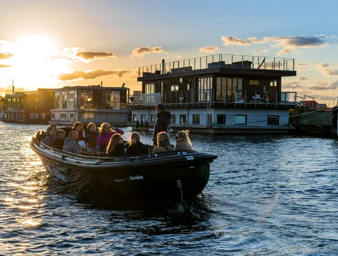 Barco pequeño del paseo por los rincones ocultos de Copenhague pasando junto a edificios modernos de Nordhavn