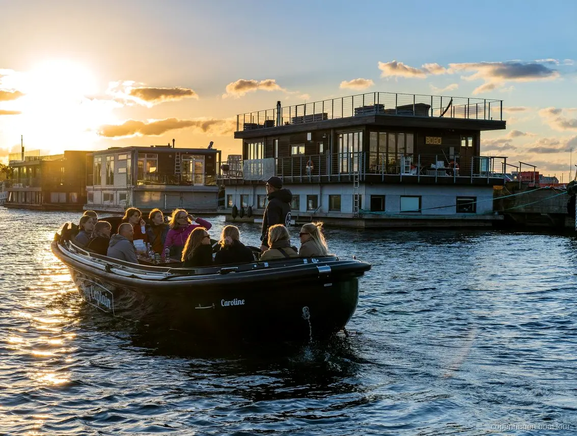 Barco pequeño del paseo por los rincones ocultos de Copenhague pasando junto a edificios modernos de Nordhavn