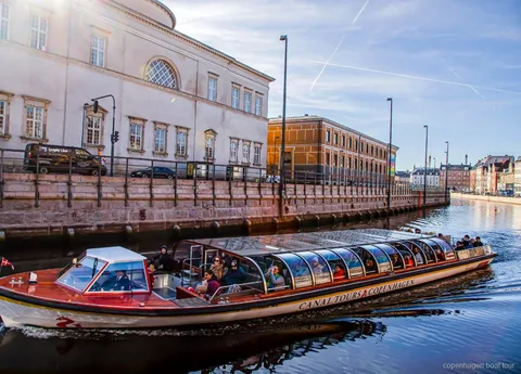Vaixell del passeig en vaixell per Copenhaguen navegant vora edificis històrics del front marítim a Ved Stranden