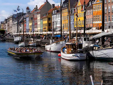 Guia narrando a rota do passeio de barco em Copenhagen perto da estátua da Pequena Sereia
