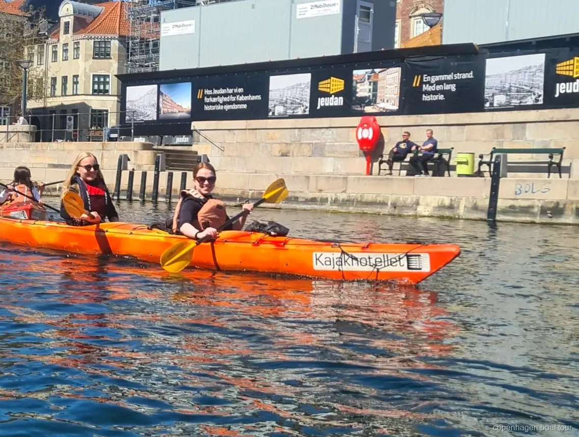 Caiacaires al tour en caiac pel port de Copenhaguen vora edificis històrics del front marítim