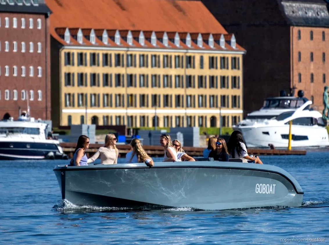 Capità guiant el vaixell elèctric pels canals de Copenhaguen a prop del Palau d'Amalienborg